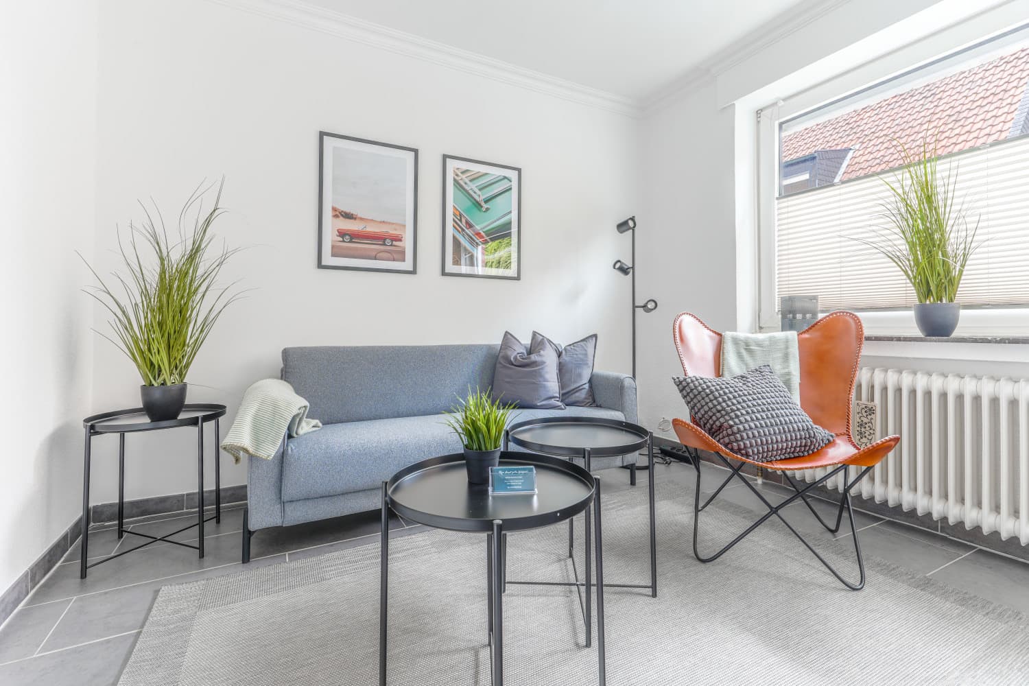 Wohnzimmer mit Sofa, Sessel und Couchtischen